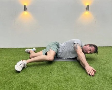 Man performing a side-lying windmill stretch