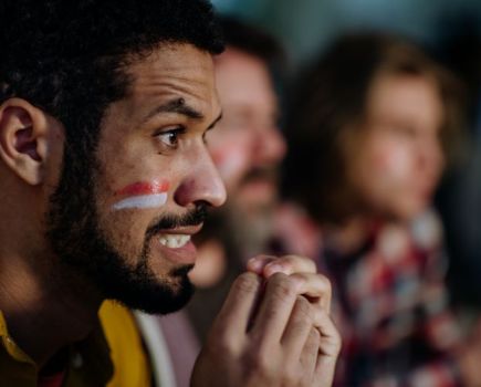 Stressed football fans watching a game on TV