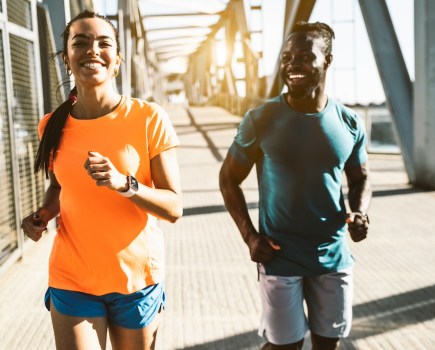 Running couple jogging training outside on run - Black man and caucasian woman runner and fitness sport on city street - Exercising, jogging and sport concept