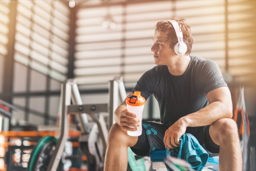 man drinking pre-workout in the gym