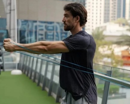 Close-up of a man performing a resistance band flye exercise