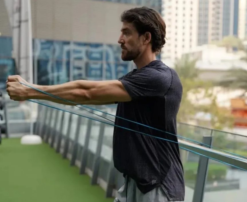 Close-up of a man performing a resistance band flye exercise