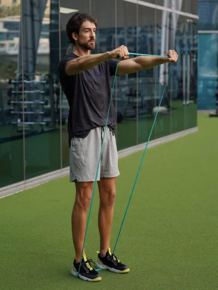 Man performing a banded front raise