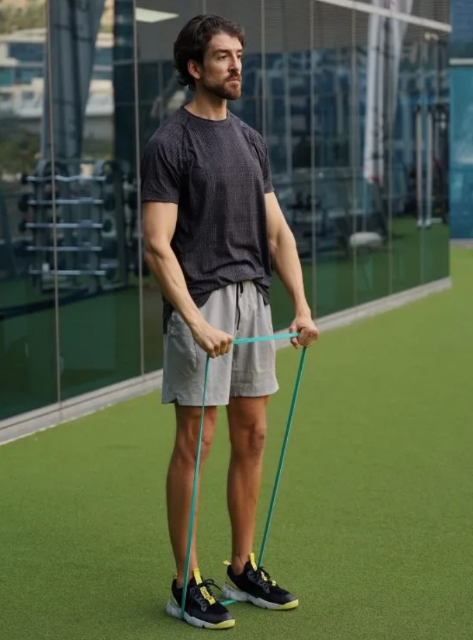 Man performing a banded front raise