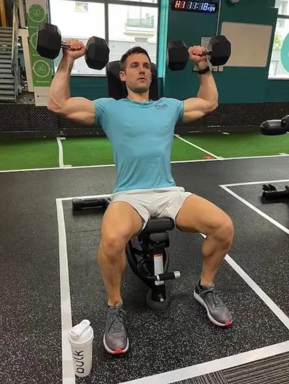 Man performing a dumbbell shoulder press