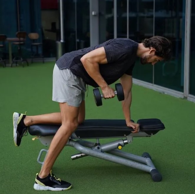 Man performing a dumbbell triceps kickback