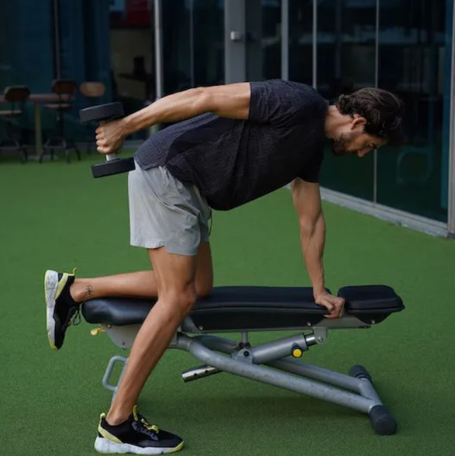 Man performing a dumbbell triceps kickback