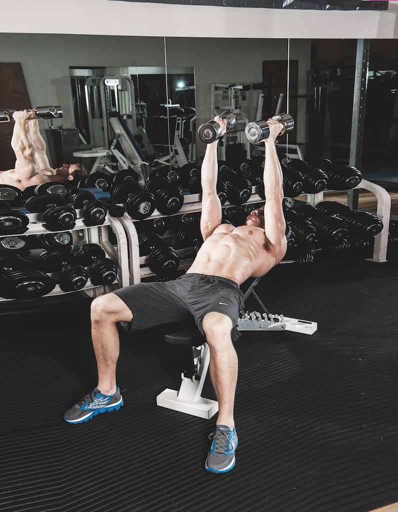 man performing incline dumbbell flye in the gym