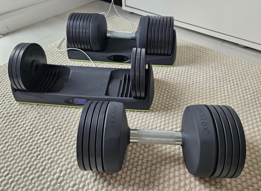 Two JaxJox adjustable dumbbells on the floor