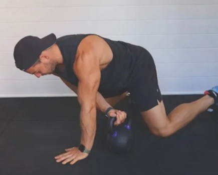 Man performing a kettlebell beast drag exercise
