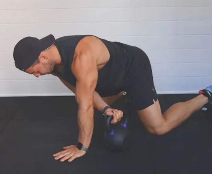 Man performing a kettlebell beast drag exercise
