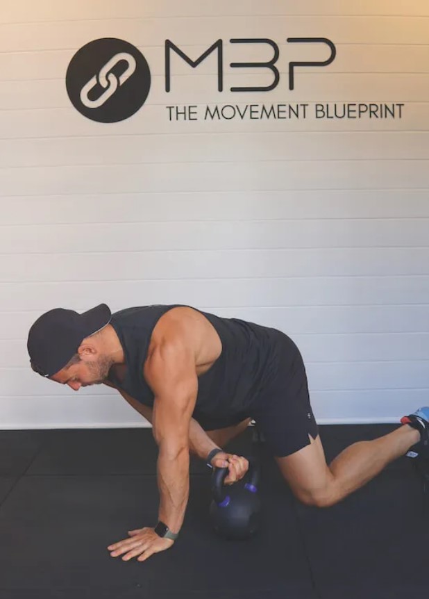 Man performing a kettlebell beast drag