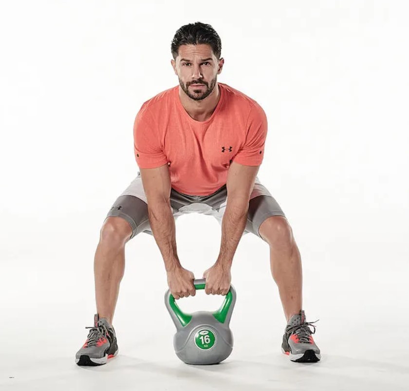 Man performing a kettlebell sumo deadlift