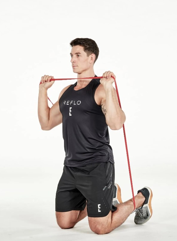 Man performing a resistance band kneeling shoulder press