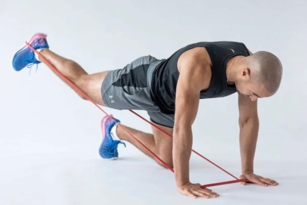 Man performing a resistance band kickback