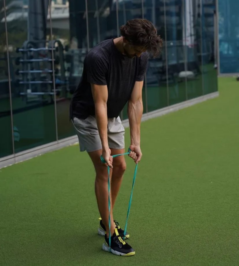 Man performing a staggered band row