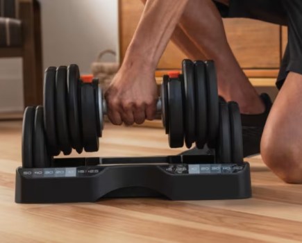 Close-up of a man's hand lifting an adjustable dumbbell