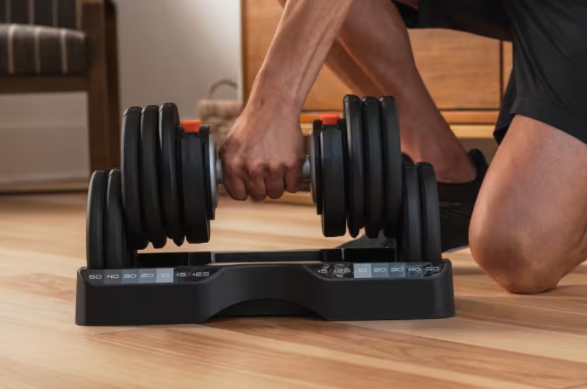 Close-up of a man's hand lifting an adjustable dumbbell