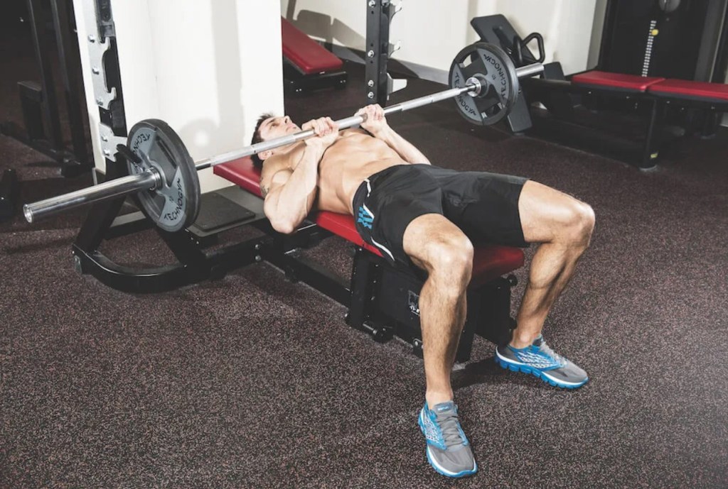 Man performing a barbell close-grip bench press exercise