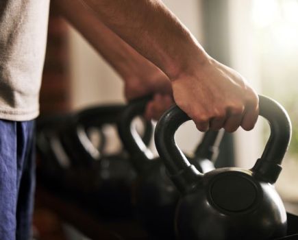 Close-up of hands clasping kettlebell handles