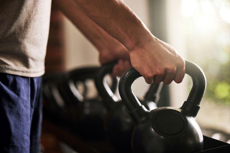 Close-up of hands clasping kettlebell handles