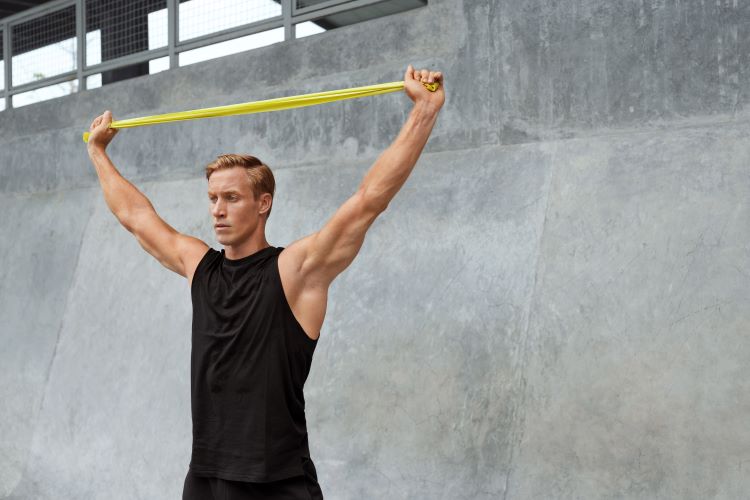 Man pulling a resistance band overhead