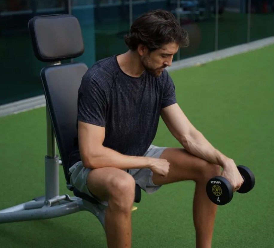 Man performing a dumbbell inverted forearm curl