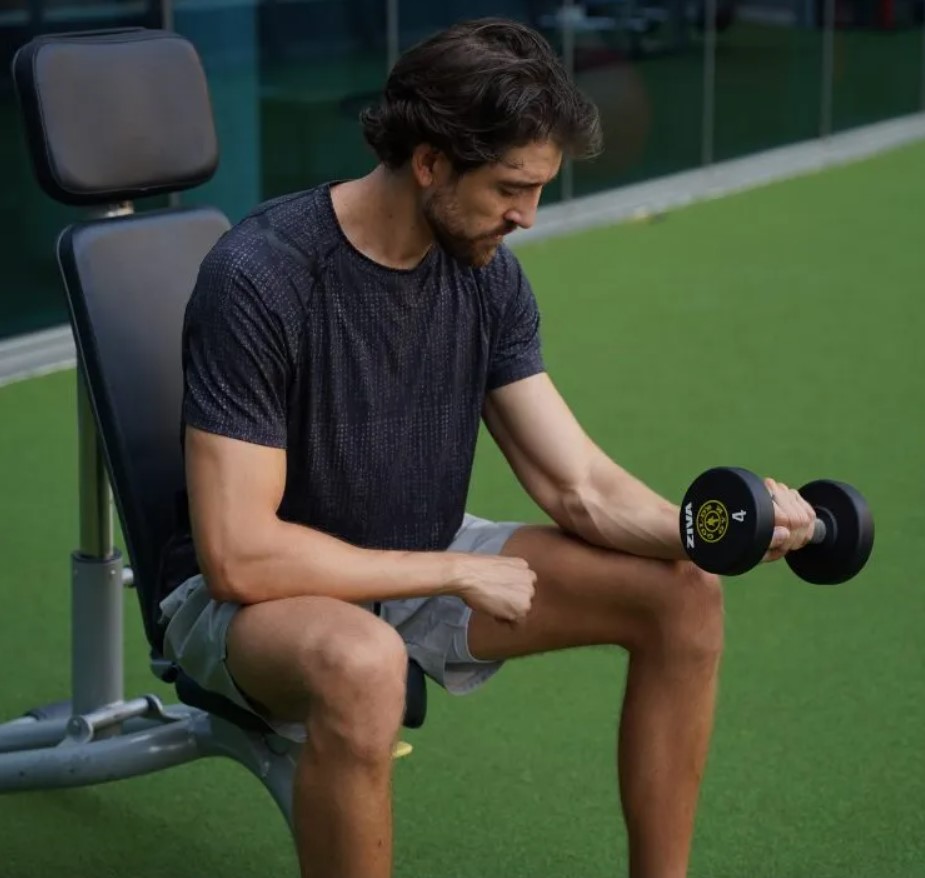 Man performing a dumbbell inverted forearm curl