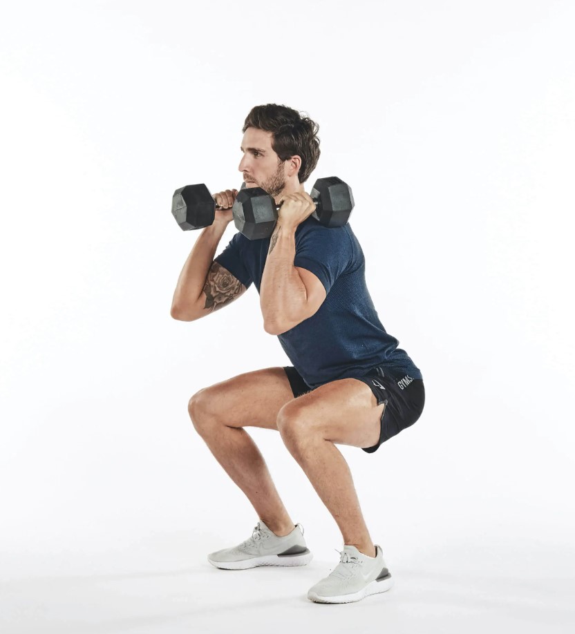 Man performing a dumbbell thruster exercise