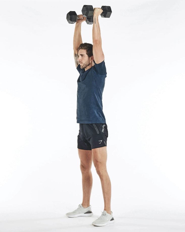 Man performing a dumbbell thruster exercise