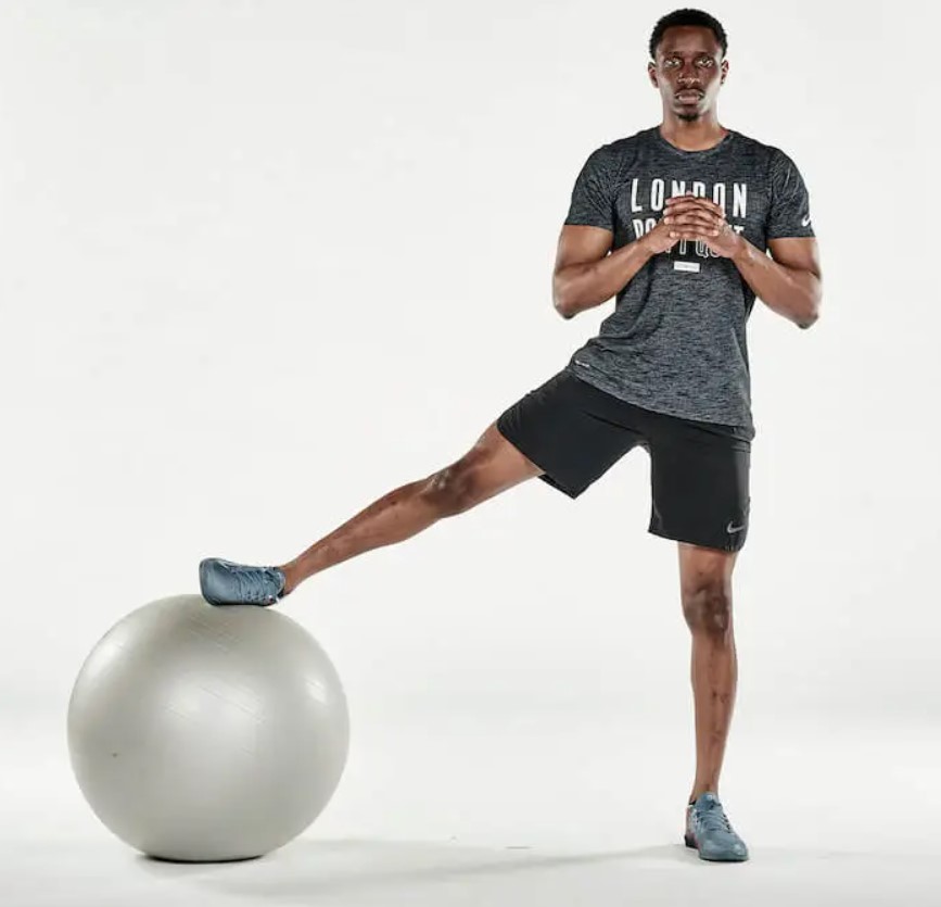 Man performing an exercise ball cossack squat 