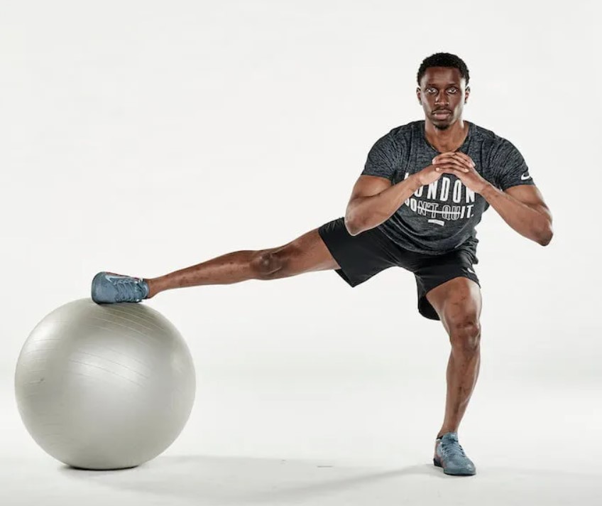 Man performing an exercise ball cossack squat 