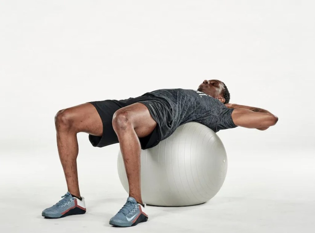 Man performing an exercise ball crunch