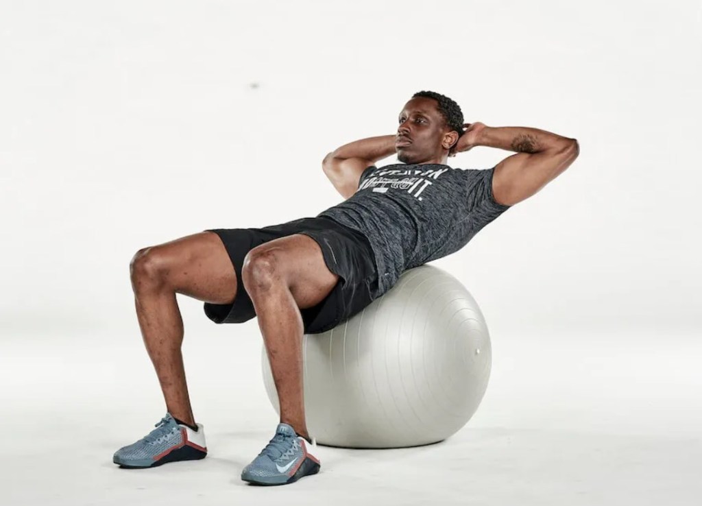 Man performing an exercise ball crunch