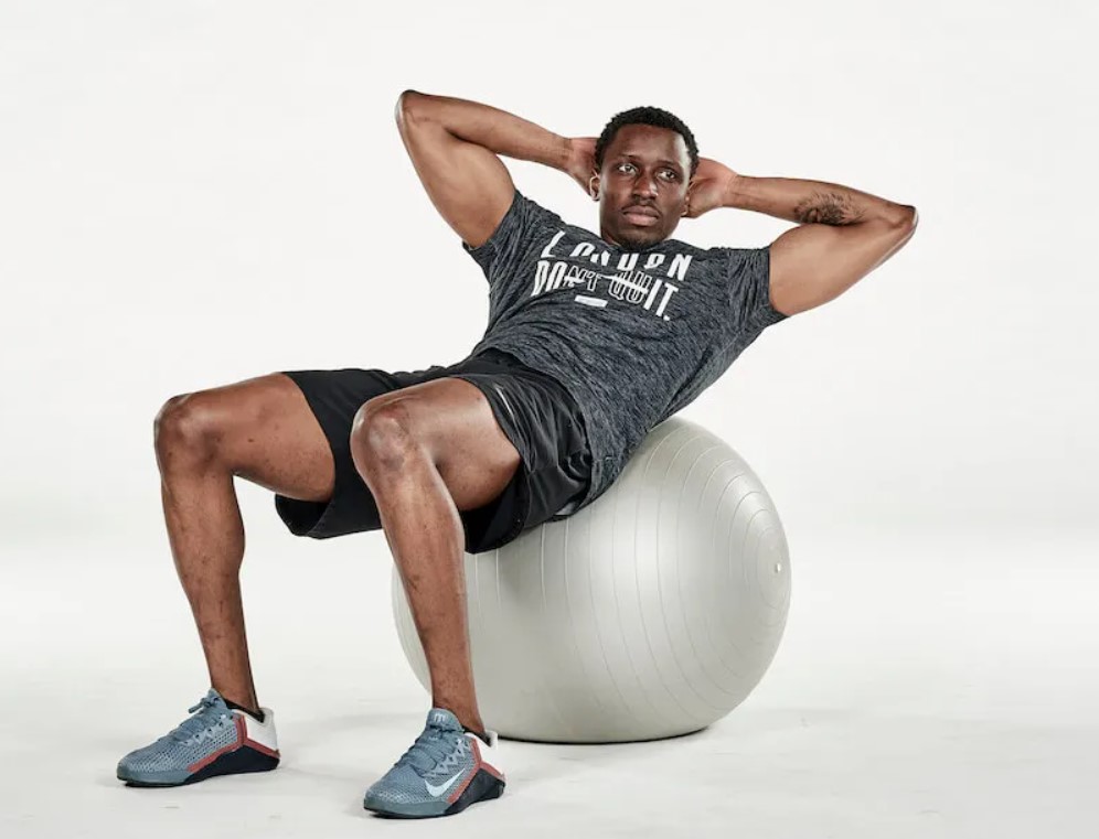 Man performing an exercise ball crunch twist