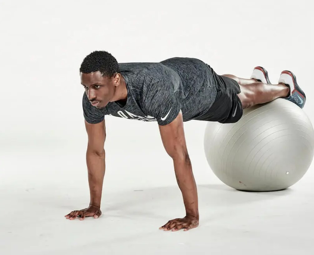 Man performing an exercise ball decline plank