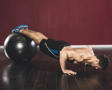 Man performing an exercise ball decline push-up