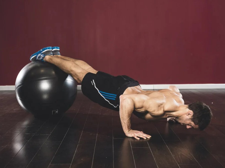 Man performing an exercise ball decline push-up