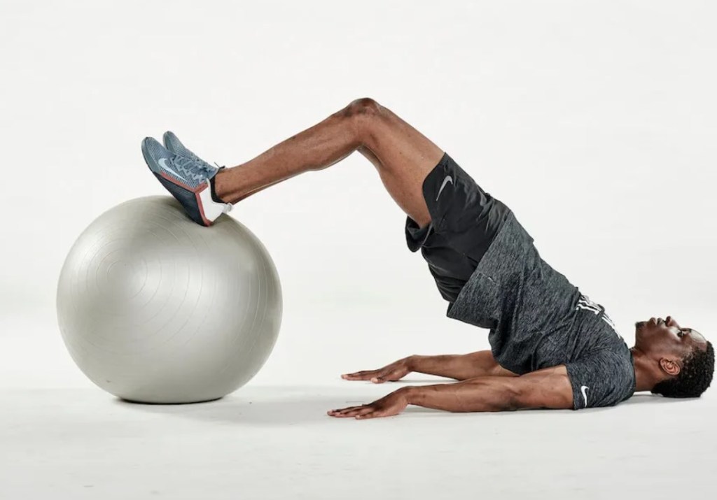 Man performing an exercise ball glute bridge