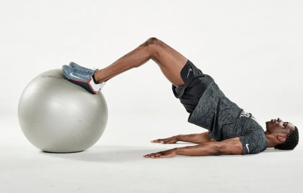 Man performing an exercise ball hamstring curl