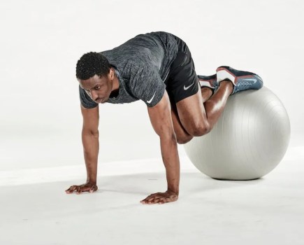 Man performing an exercise ball jack-knife twist