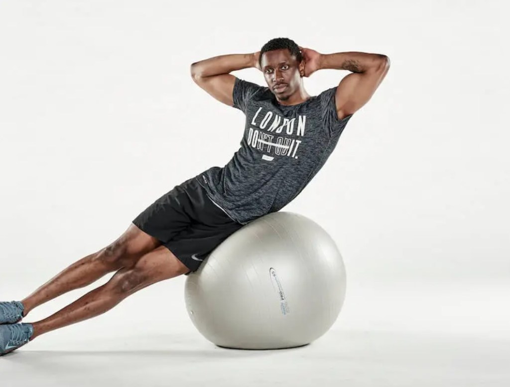 Man performing an exercise ball oblique crunch