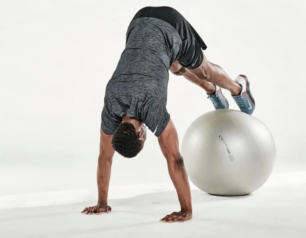 Man performing an exercise ball pike