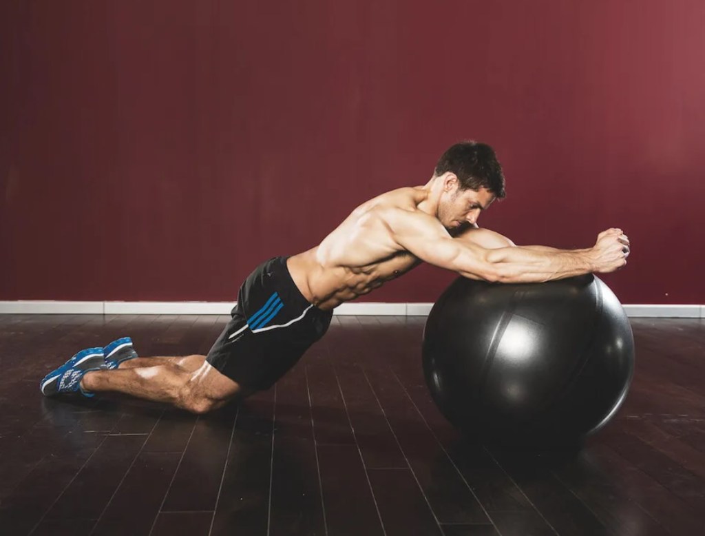 Man performing a gym ball roll-out exercise