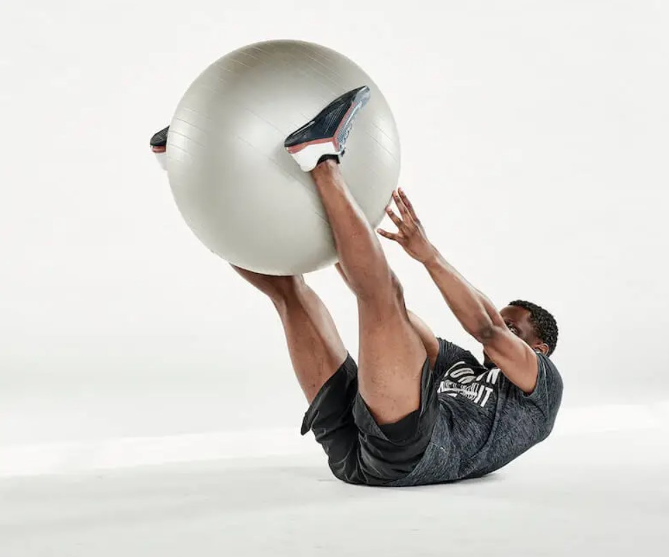 Man performing an exercise ball V-up