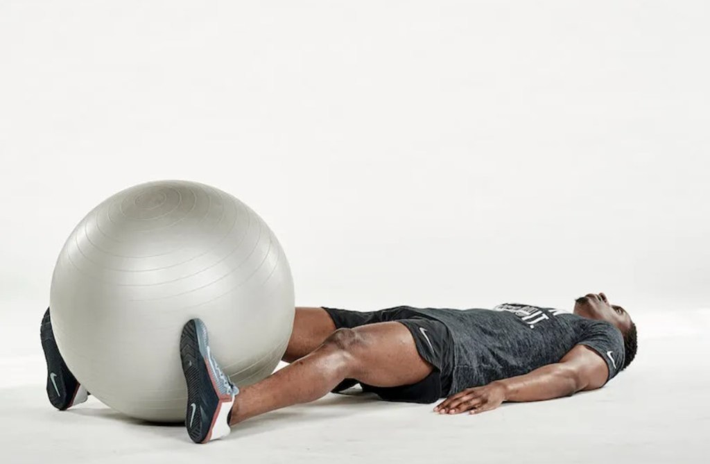 Man performing an exercise ball V-up