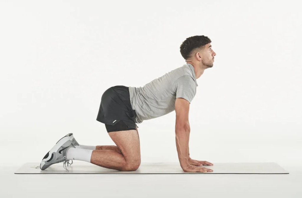 Man performing a cat cow yoga pose