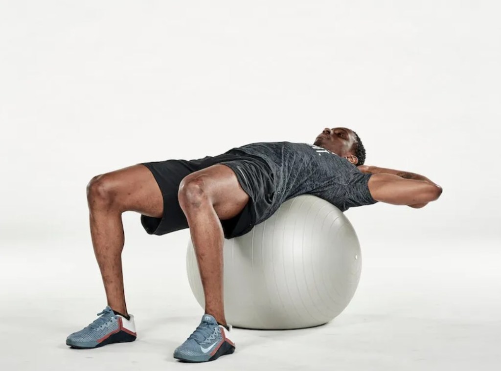 Man performing an exercise ball crunch twist