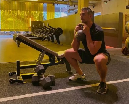 Man in a gym performing a kettlebell goblet squat