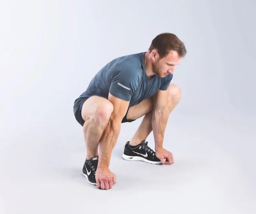 Man performing a squat to stretch